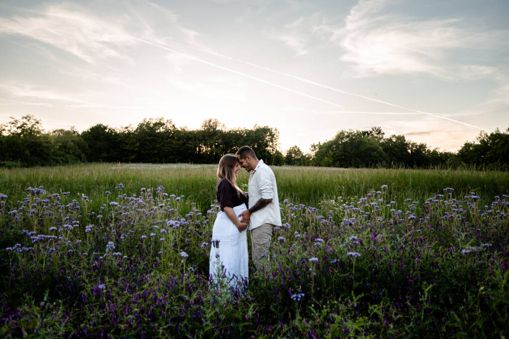 Photo de couple au coucher de soleil dans un champs de fleur