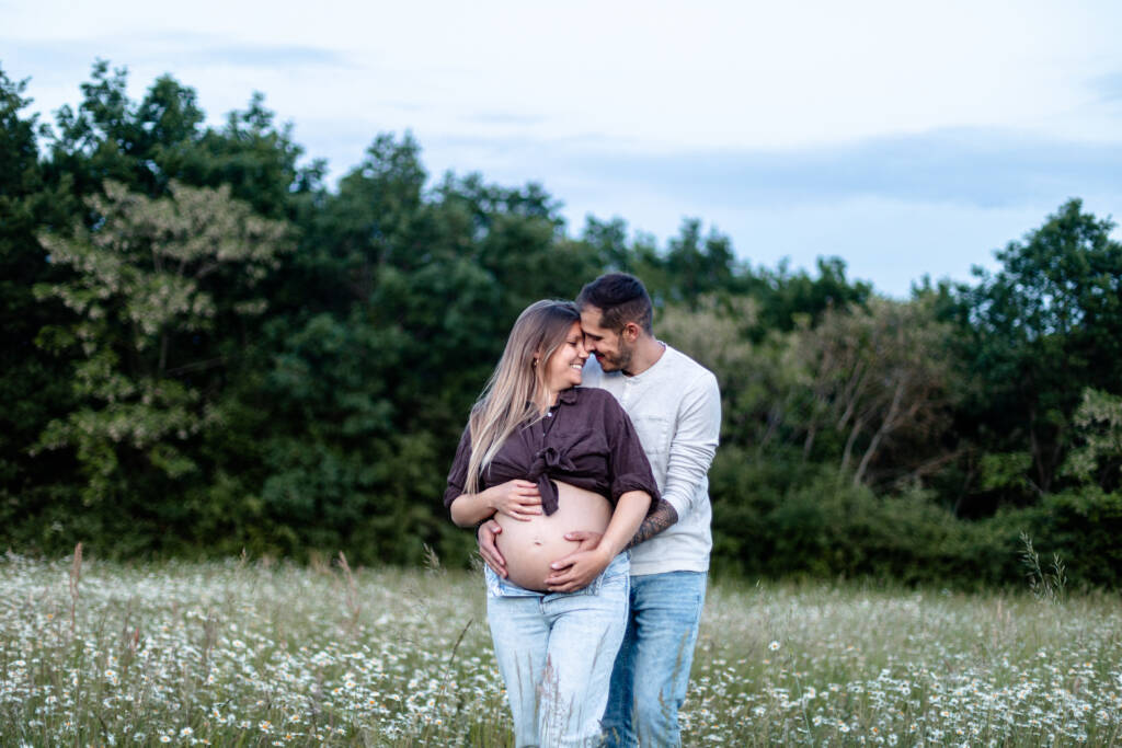 Couple amoureux, se faisant un calin les mains posées sur le ventre de la femme enceinte